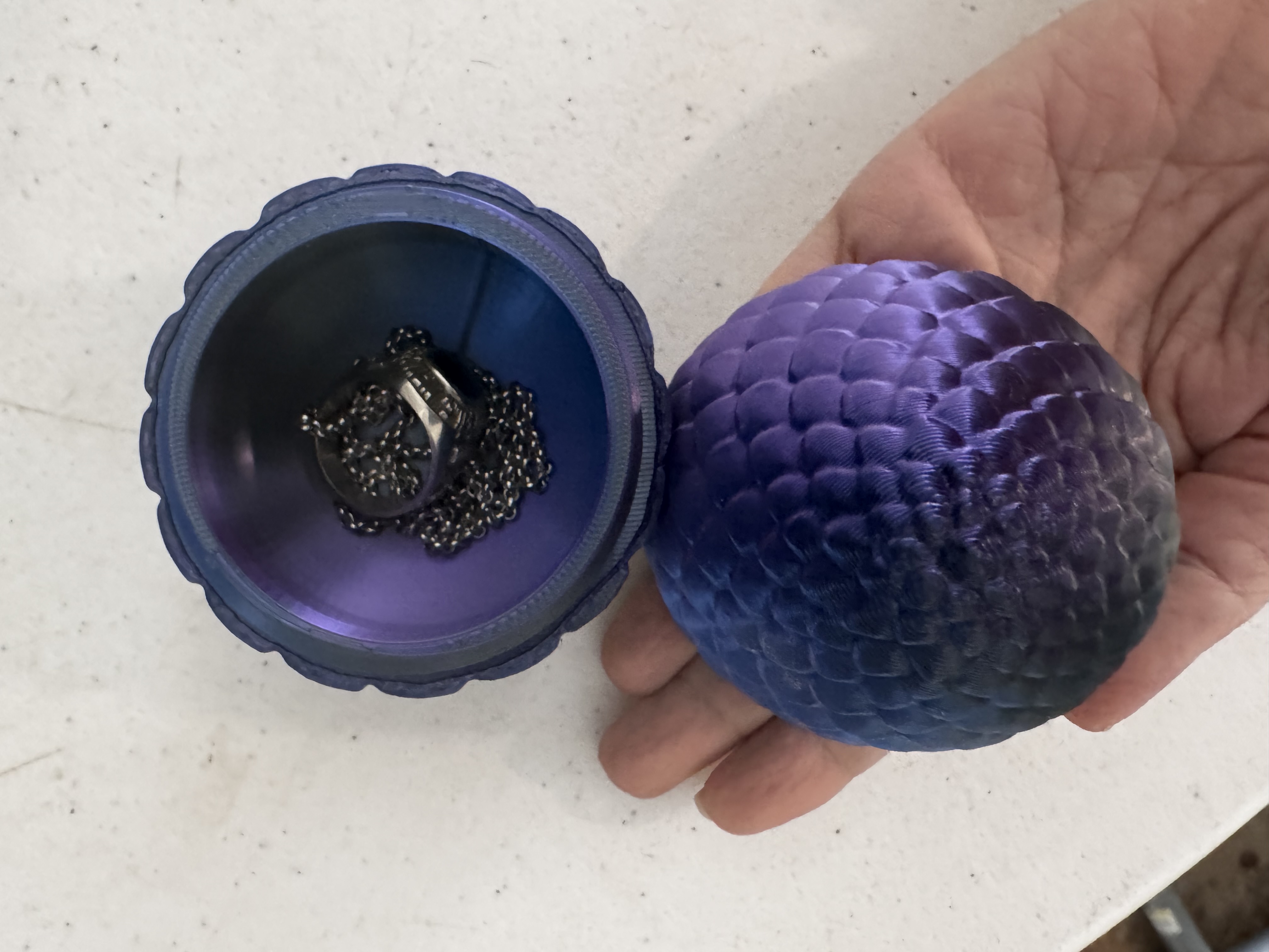 Purple and blue silk dragon egg jewelry box holding a necklace