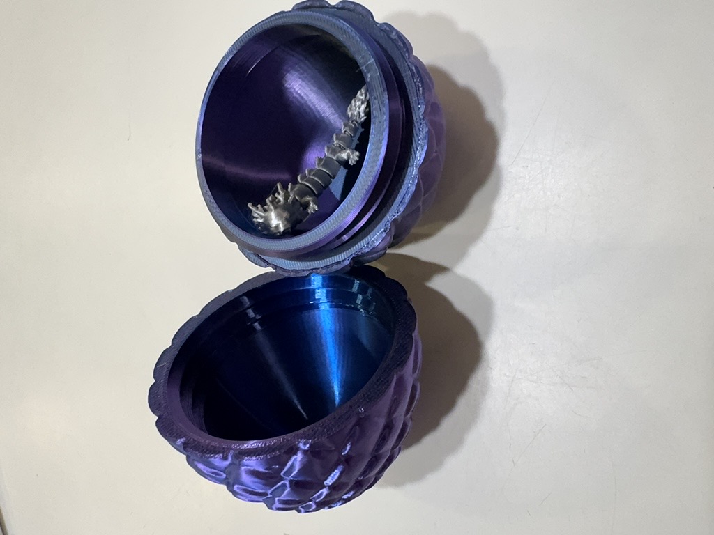 Purple silk dragon egg open with a tiny silver dragon inside