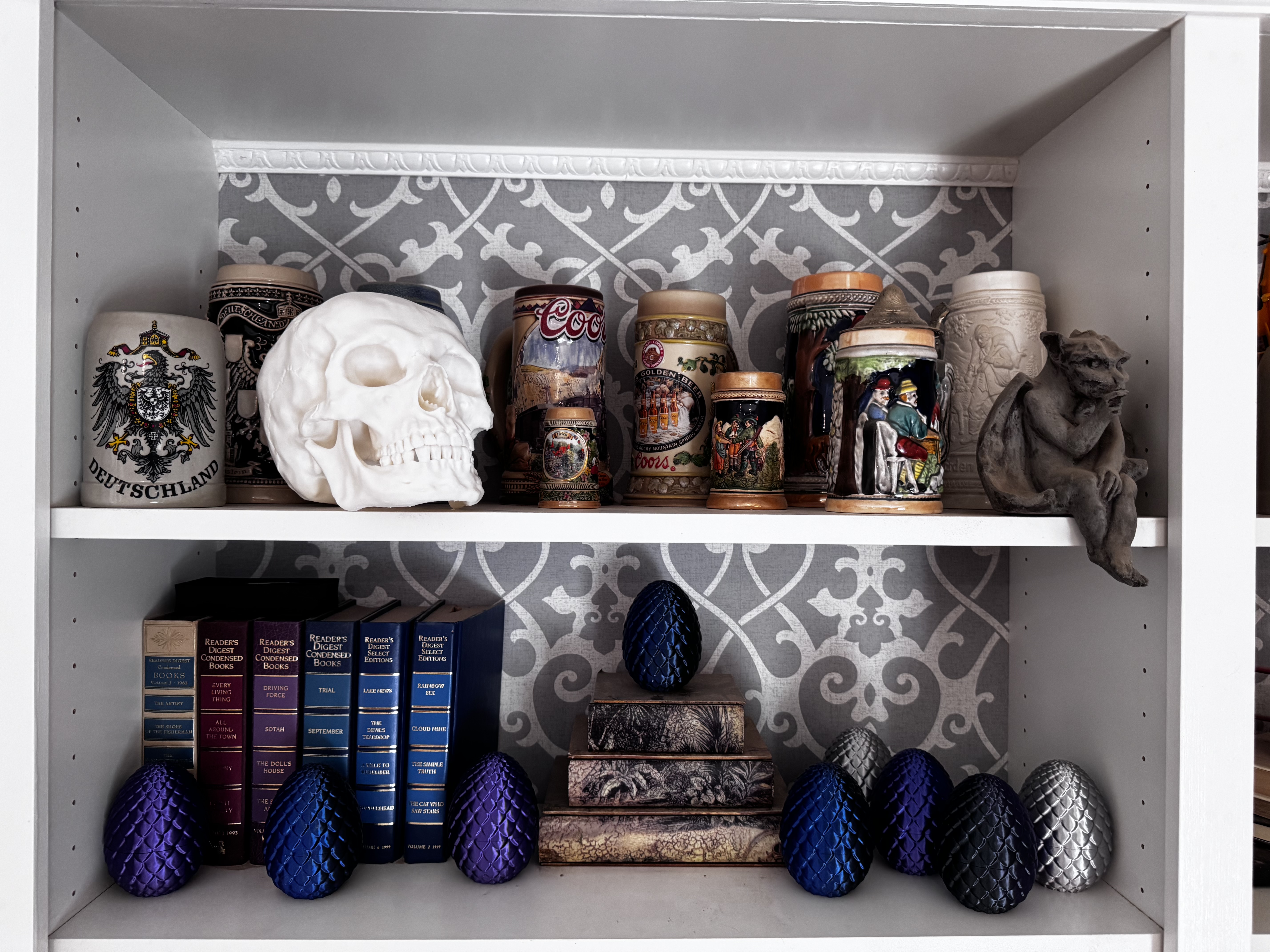 A collection of dragon eggs in purple, blue, black, and silver silk on a shelf